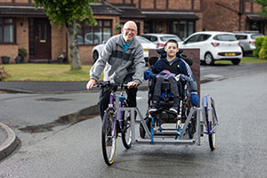 An older man on an Insync Bike and young boy on special needs trike